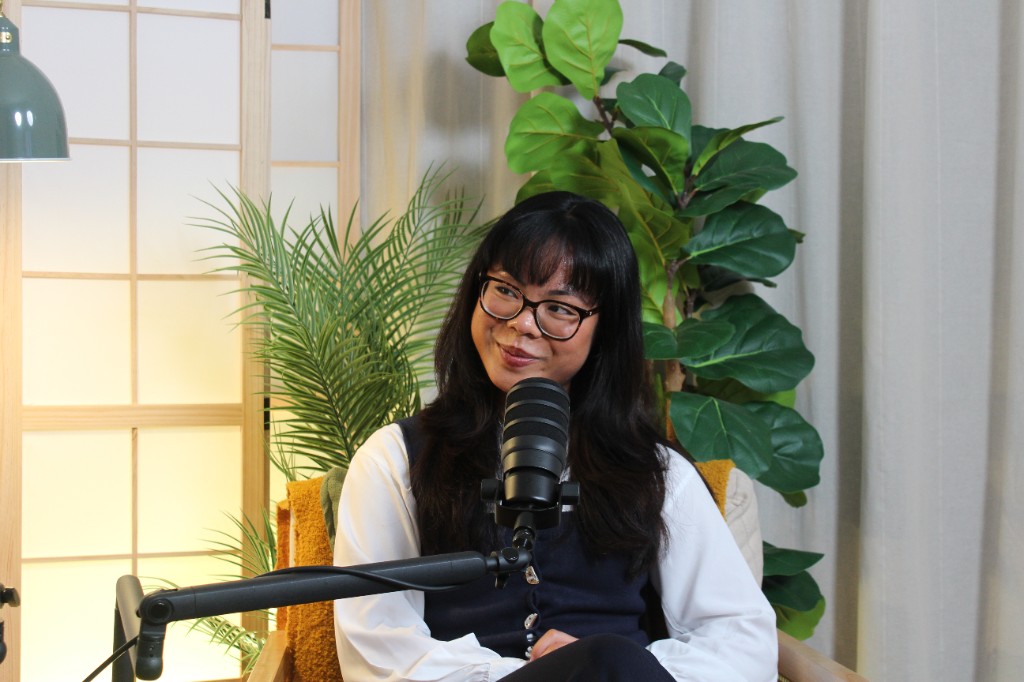 Guest with glasses speaking into a studio microphone during an Investate podcast recording
