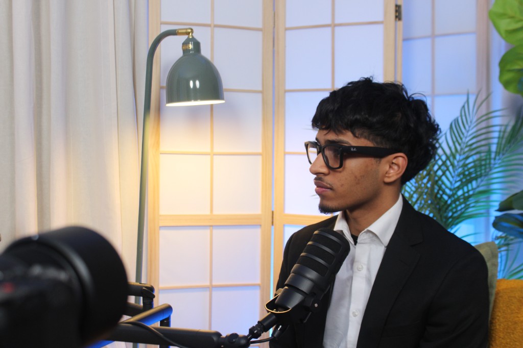 Guest in professional dress at a broadcast microphone during recording