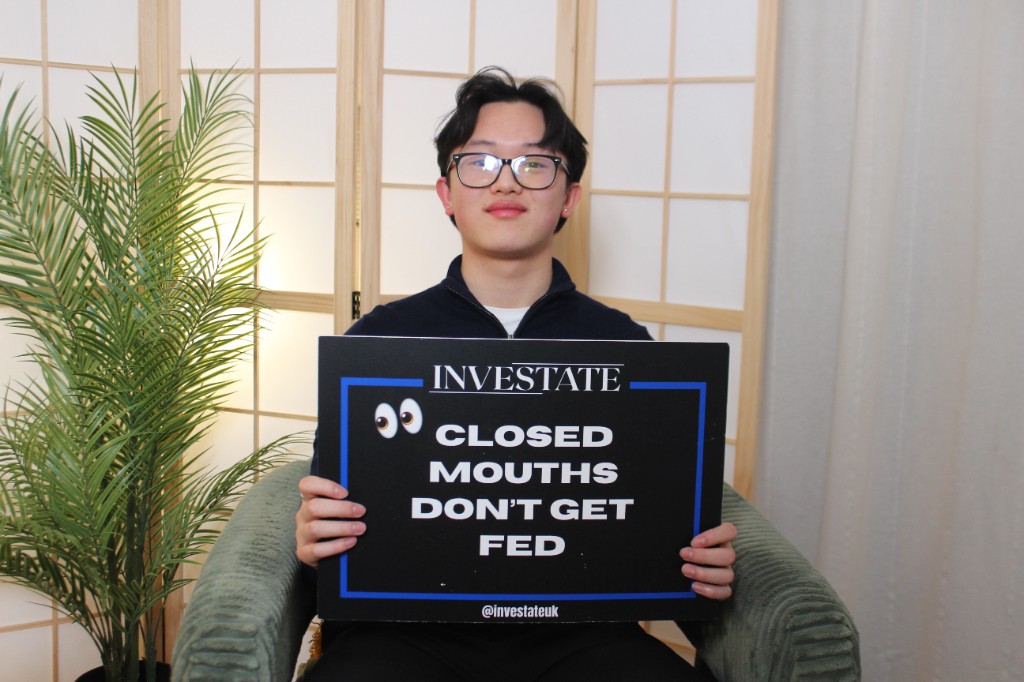 Guest holding an Investate board with the quote Closed mouths do not get fed