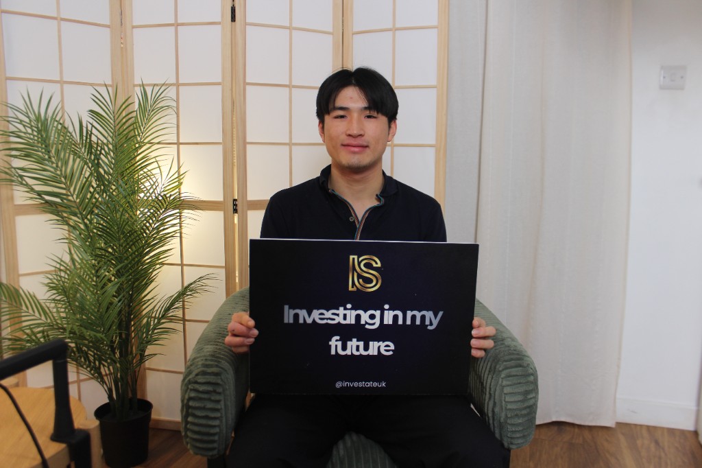 Guest holding an Investate board with Investing in my future and the IS mark