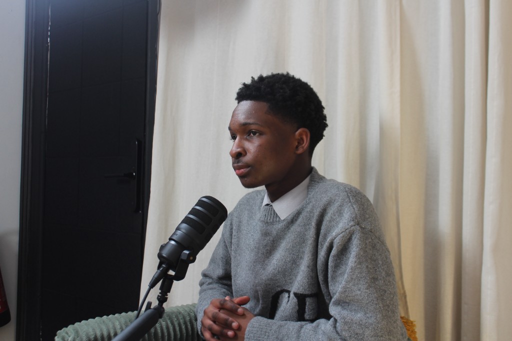 Guest seated at a microphone during an Investate podcast recording